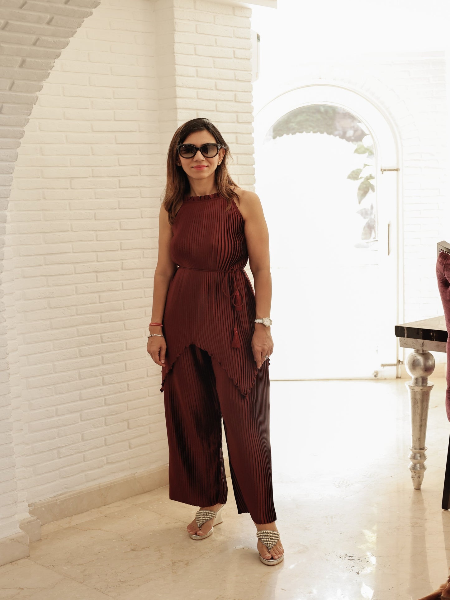 THE AMIRA SET -THIS EXQUISITE ENSEMBLE FEATURES A MAROON PLEATING HIGH LOW HEM BLOUSE PAIRED WITH FLARED PANTS